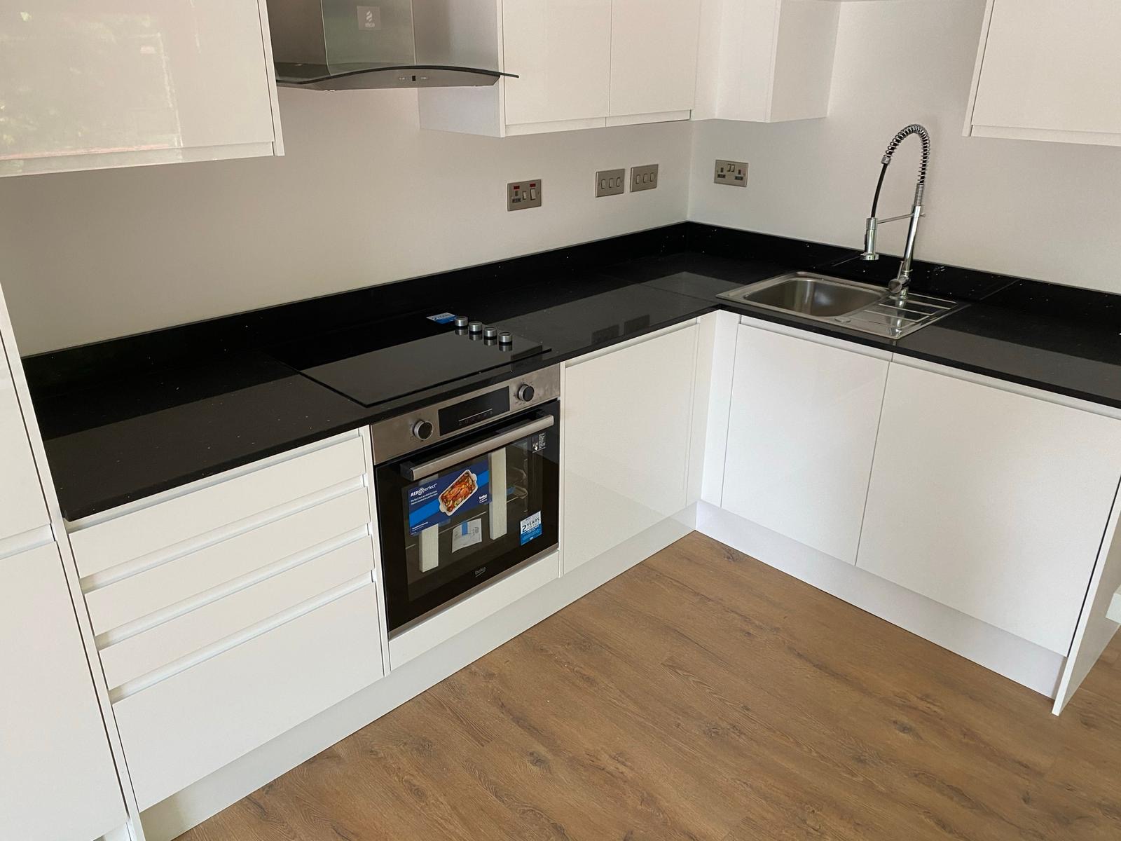 Completed white kitchen with black worktops